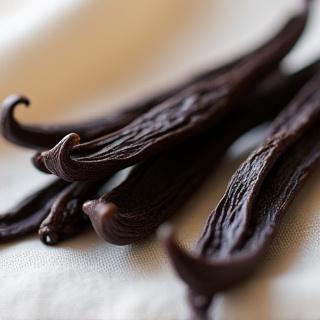 Vainas de vainilla aromáticas sobre un paño de lino, con luz suave incidiendo.